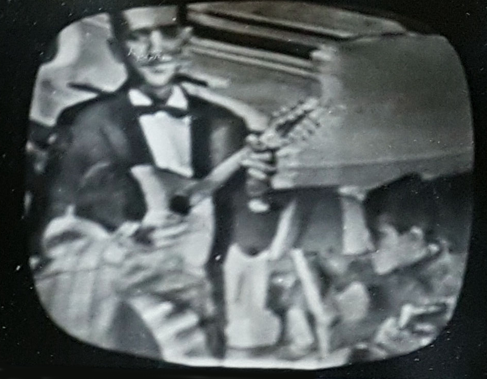 Registros da tela da televisão: Seu Jorge e os filhos ao lado de Jacob do Bandolim.